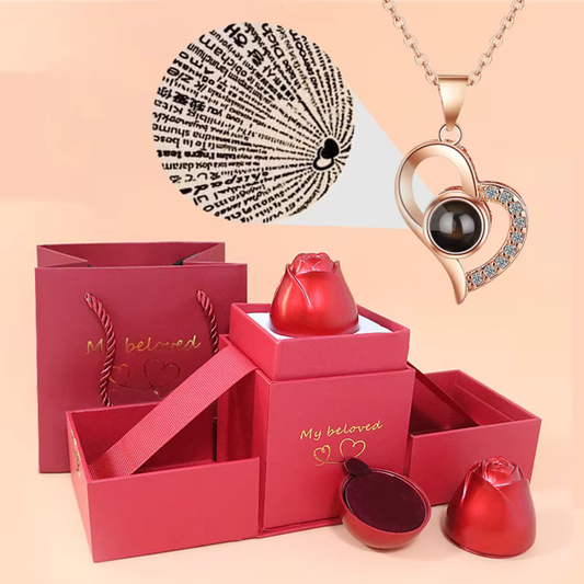 Rosa ascendente en caja con collar de plata que refleja te amo en 100 idiomas